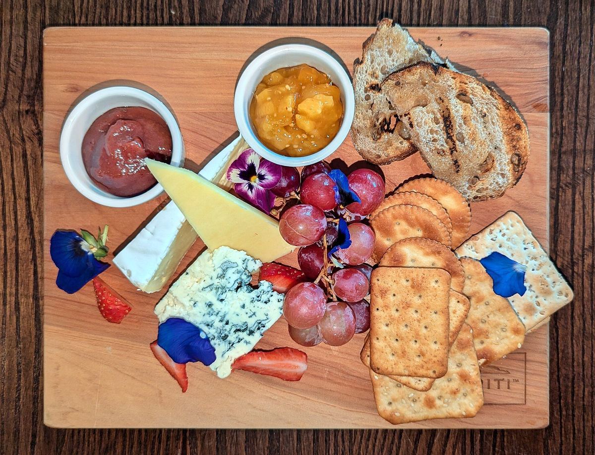 Plateau de fromages, raisins et craquelins.